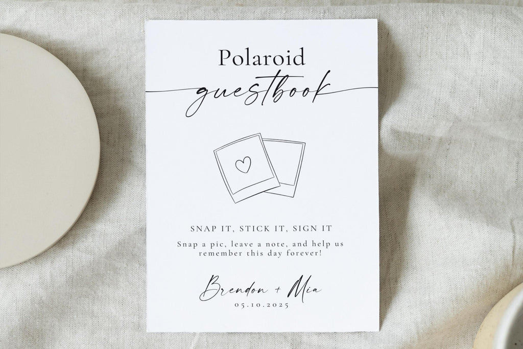 Clean flat lay of printable Polaroid guestbook sign with heart photo and calligraphy font - perfect DIY wedding guest book station sign for couples using Polaroid cameras.
