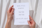 Minimalist shuttle service wedding sign template held in hands with neutral draped backdrop, modern wedding transportation sign printable editable in Canva for wedding guests