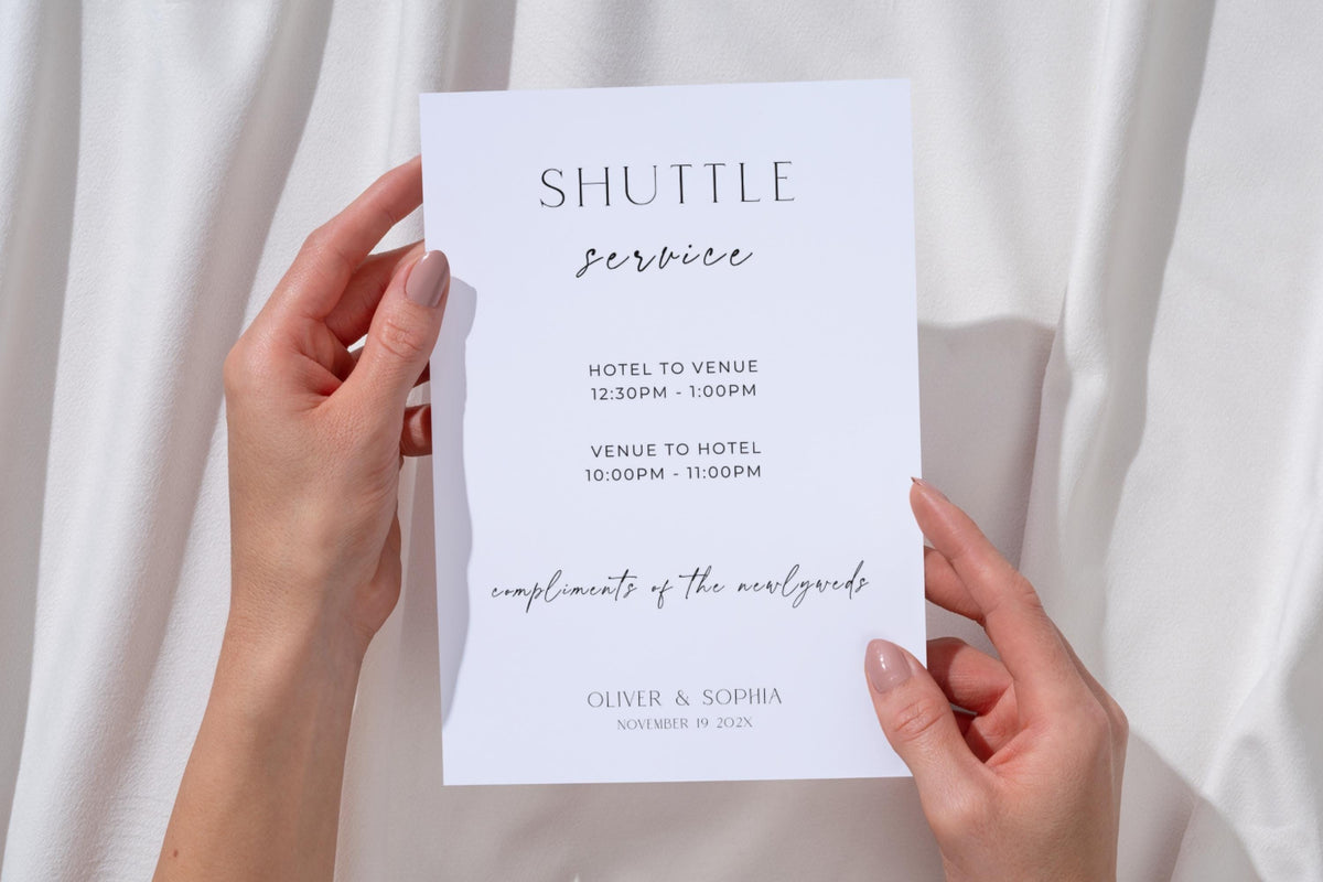 Minimalist shuttle service wedding sign template held in hands with neutral draped backdrop, modern wedding transportation sign printable editable in Canva for wedding guests
