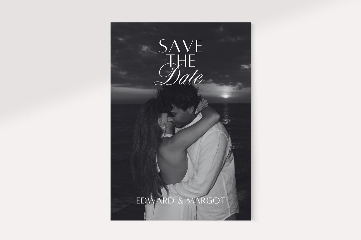 Black and white photo save the date card design featuring a kissing couple, elegant serif and script lettering, and names at the bottom for a romantic old money wedding announcement.