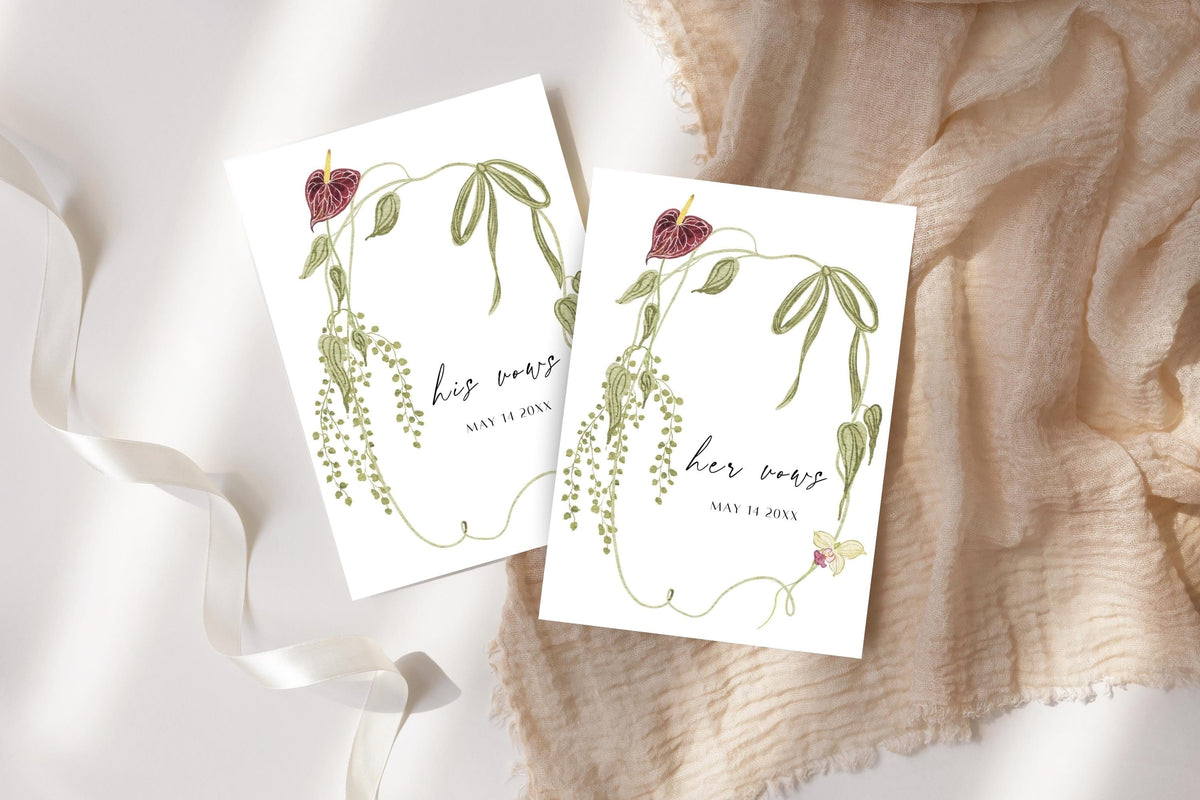 His and her wedding vow books with green botanical borders and burgundy floral details, styled on ivory fabric with white ribbon. Romantic printable wedding vow booklet templates for a garden wedding ceremony.