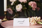 Modern flat wedding name card template with calligraphy guest name, styled on a blush plate with romantic pink wedding flowers.