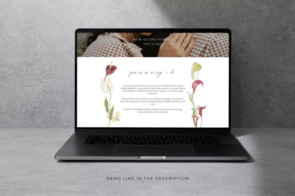 Wedding website design preview on a laptop against a grey stone background, featuring a soft floral wedding page and clean, elegant layout.