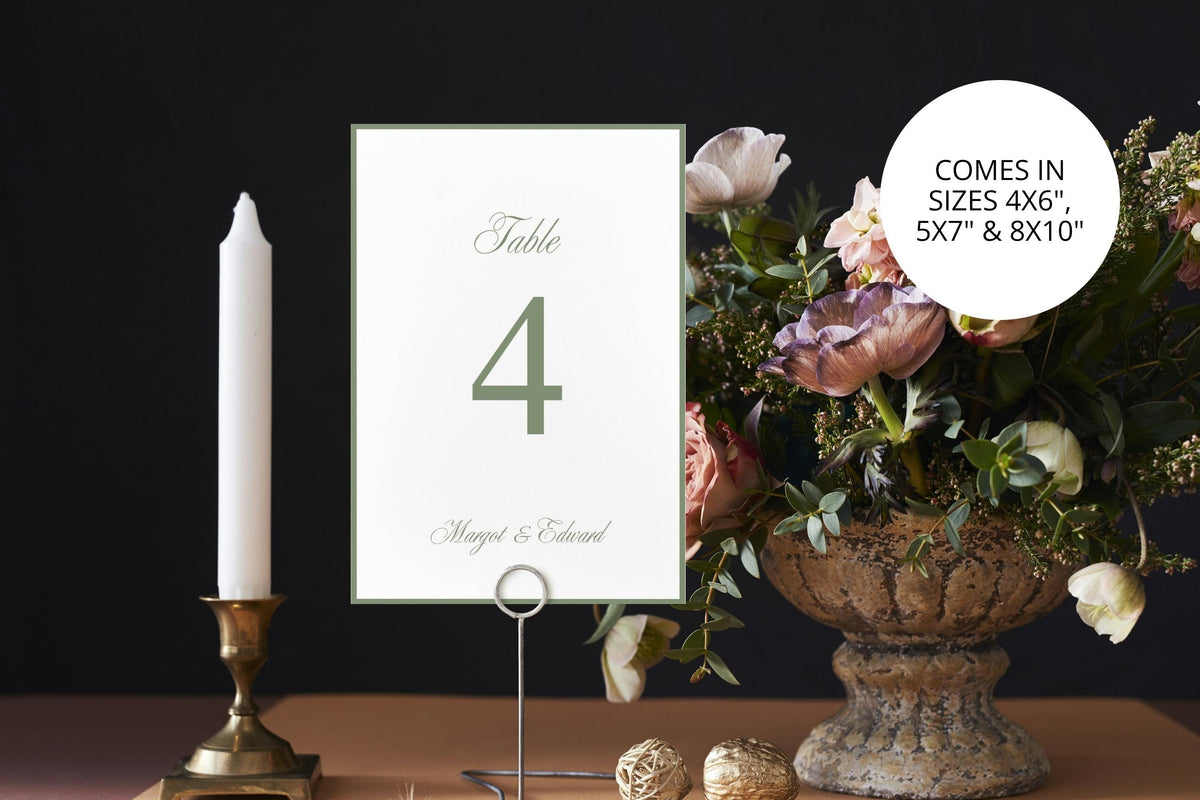 Classic sage green wedding table number beside a brass candlestick and romantic floral arrangement against a dark background, with printable 4x6, 5x7 and 8x10 inch size options for elegant reception tables.