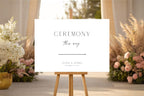 Editable wedding ceremony sign template in Canva displayed on easel, modern wedding ceremony entrance sign, minimalist wedding signage printable, elegant black and white wedding decor, DIY wedding sign instant download.