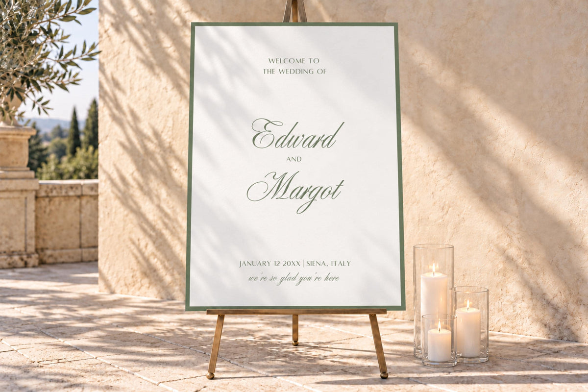 Ivory wedding welcome sign with a sage green border and romantic script names, displayed on a wooden easel beside glass pillar candles against a sunlit stone wall for an elegant outdoor wedding entrance.