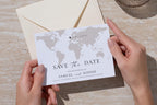 Save the date card being placed into an envelope, minimalist map wedding template showing neutral beige tones, editable in Canva for printable stationery.