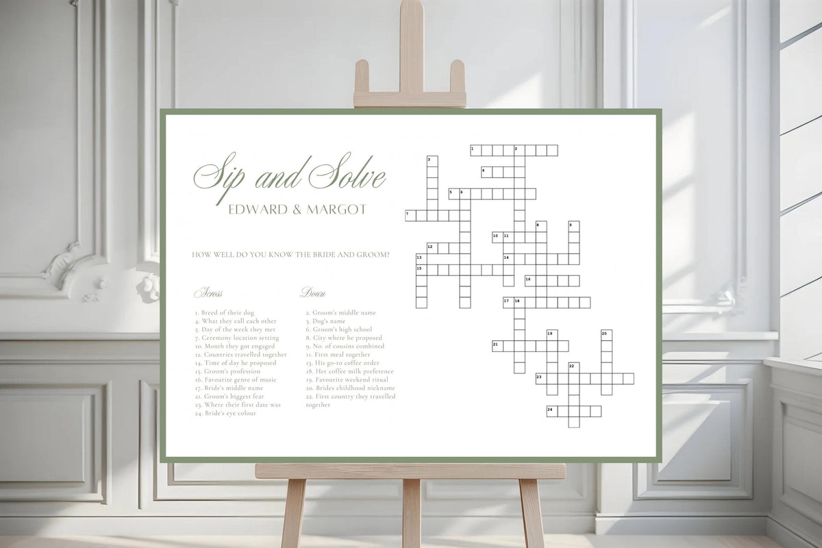 Sage bordered wedding crossword game sign displayed on an easel in a bright, elegant indoor wedding venue with white panelled walls.