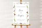 Romantic burgundy floral wedding welcome sign on wooden easel, editable Canva wedding sign template with orchid botanical border and elegant script names