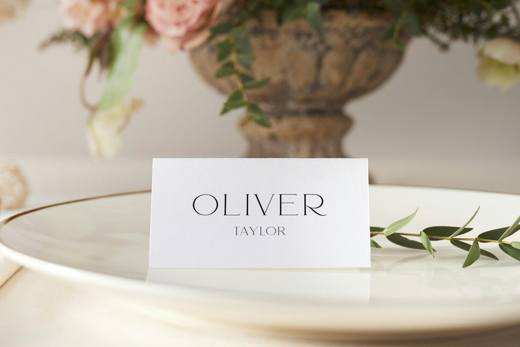 flat wedding place card mockup on plate, minimalist name card design with modern serif font, elegant neutral wedding table styling, simple luxury reception decor