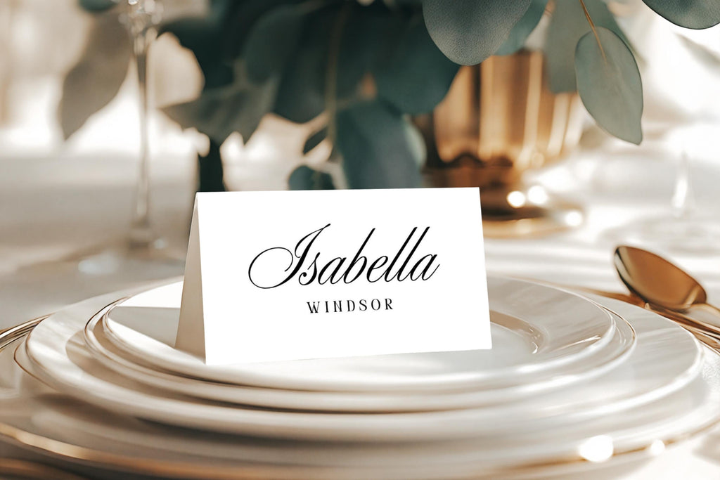Elegant wedding place card on white plate with gold cutlery, editable Canva place card template, old money script font name card for wedding table settings.