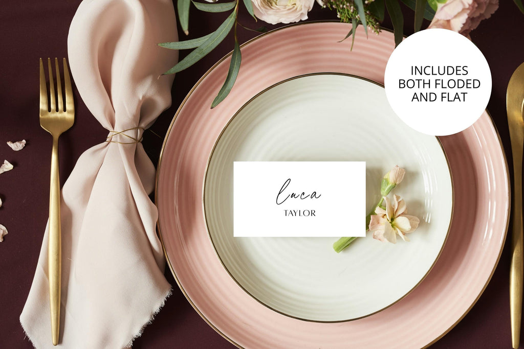 Printable folded wedding place card template displayed on a blush pink plate setting with romantic florals and modern table décor.