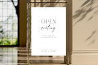 Framed open seating wedding sign template displayed in luxury wedding venue, editable wedding reception signage, modern minimalist wedding decor printable, black and white open seating sign, elegant wedding entrance display, instant download Canva template.