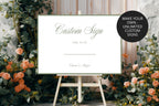 Editable custom wedding sign template displayed among colourful garden flowers, with a note that you can create unlimited custom signs.