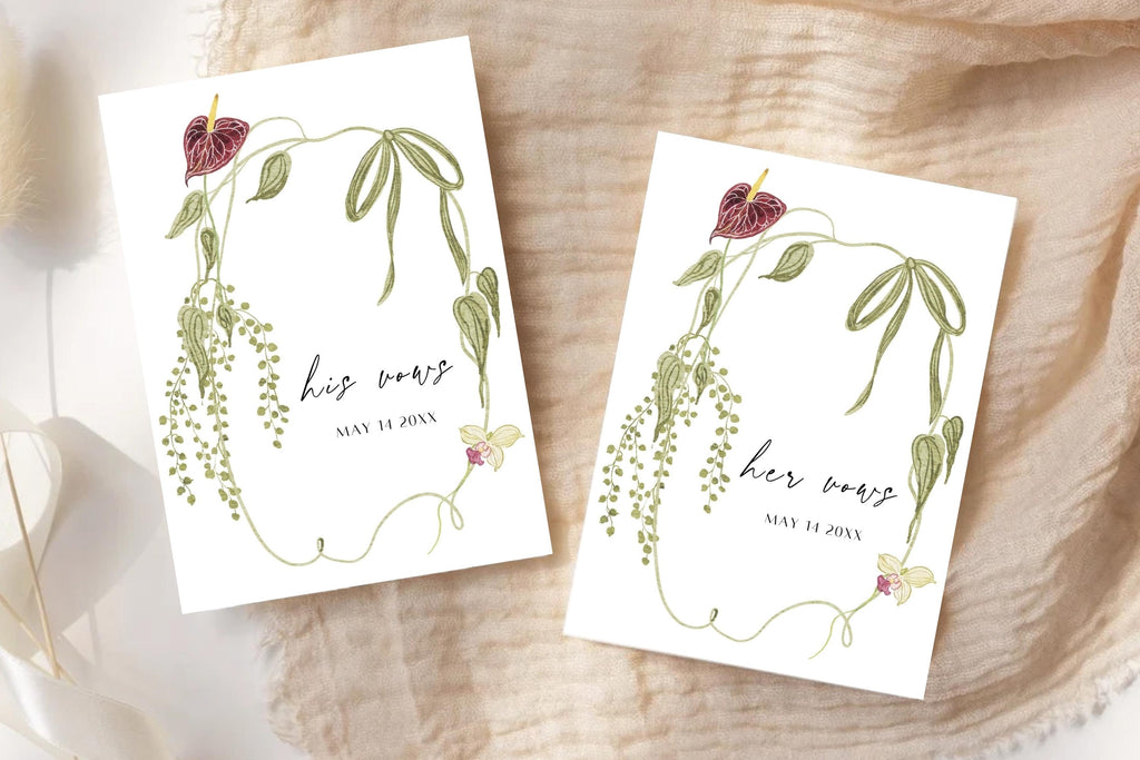 Matching his and her vows booklet templates with elegant script lettering, green trailing botanical borders and burgundy flowers. Personalised wedding ceremony vow books displayed on soft beige fabric in natural light.