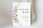 Love in Bloom wildflower mimosa bar sign template displayed on table, printable wedding bar sign with floral design, editable Canva bridal shower décor