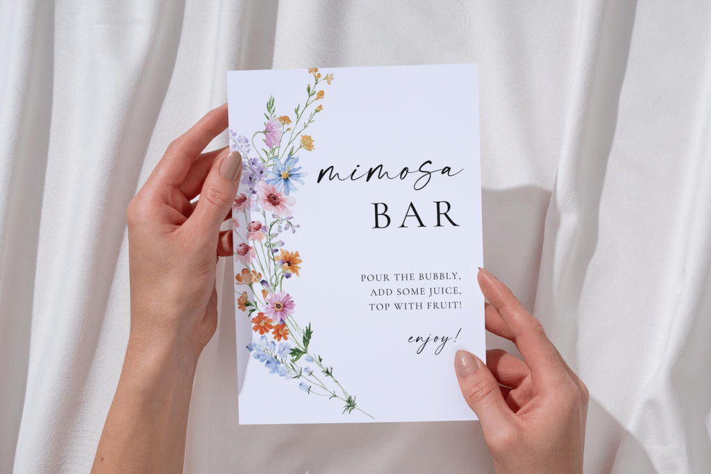 Hands holding printable mimosa bar sign with wildflowers, editable Canva bridal shower drinks station sign, modern boho wedding bar signage template