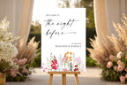Elegant floral rehearsal dinner sign mockup on an easel, styled with soft pink and white wedding flowers.