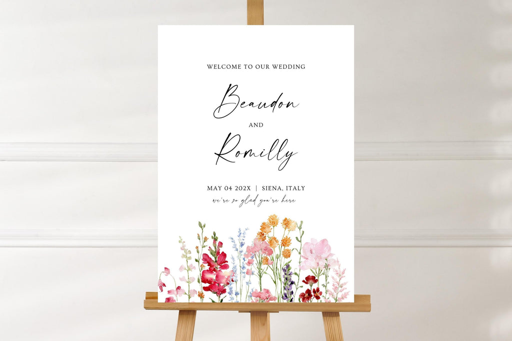 Customisable wedding welcome sign mockup against a soft white wall, featuring colourful floral illustrations and elegant script names for a romantic wedding entrance.