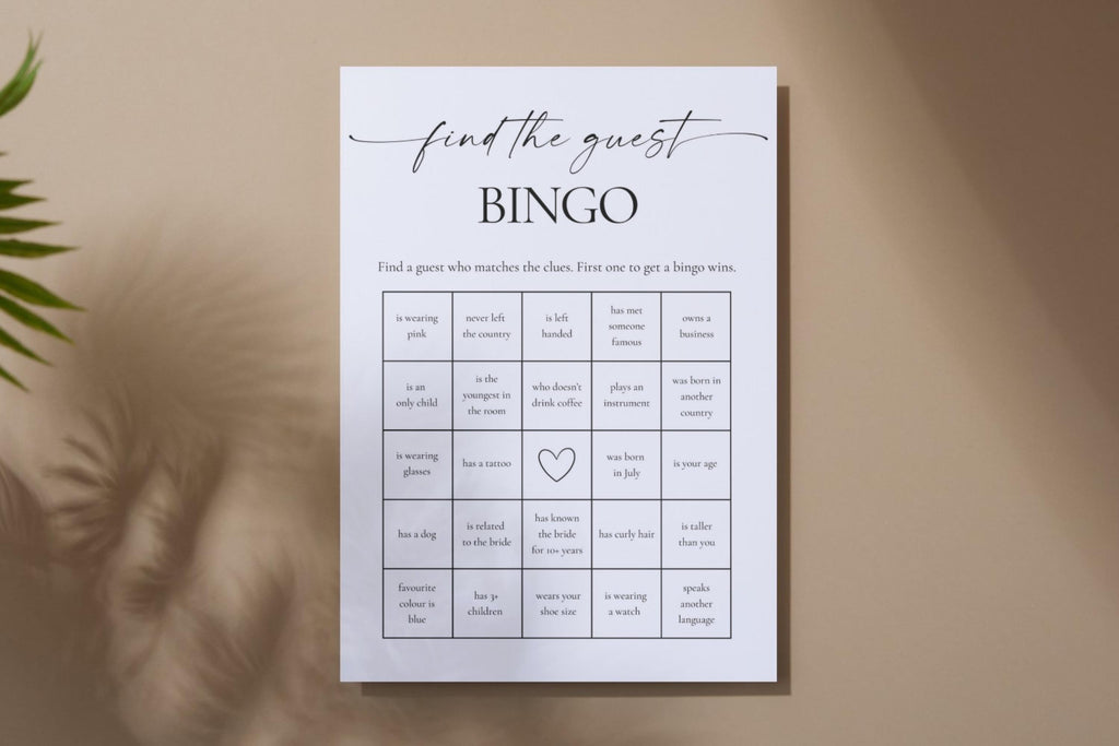 Minimalist printable bridal shower bingo game on neutral wall with palm leaf shadows. Perfect editable Canva template for wedding guest icebreaker