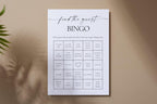 Minimalist printable bridal shower bingo game on neutral wall with palm leaf shadows. Perfect editable Canva template for wedding guest icebreaker