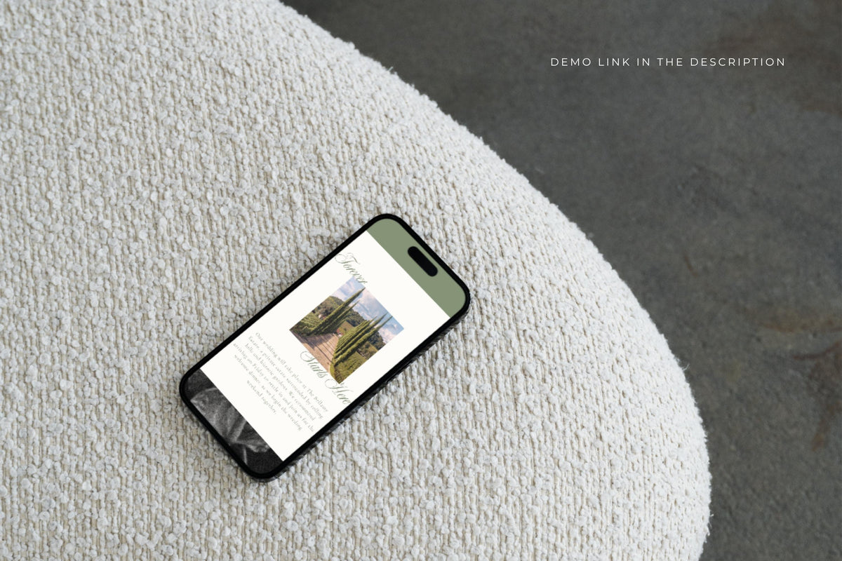 Mobile-friendly sage green wedding website template displayed on a phone resting on a textured cream surface, showing wedding location information and a venue photograph.