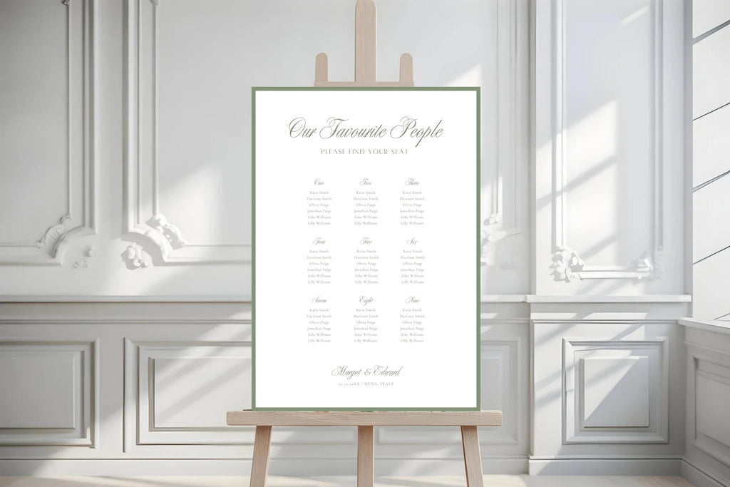 Minimalist sage green wedding seating plan displayed on an easel against white panelled walls with natural sunlight and shadows. Old money wedding table chart featuring elegant script, a green border and organised guest lists.