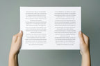 Open wedding vow booklet held in two hands, showing personalised wedding vows printed across two white interior pages. Printable marriage vow book template for couples to read their promises during the wedding ceremony.