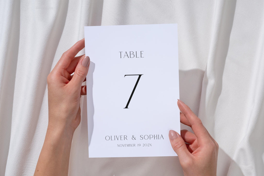 Minimalist wedding table number printable, table 7 sign held in hand, clean modern wedding signage, editable Canva template, simple elegant reception decor idea