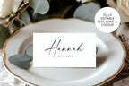 Elegant printable wedding place cards in black and white with editable text and font, displayed on classic gold-rimmed plate