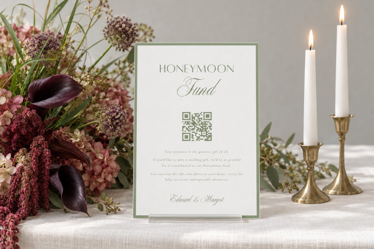 Sage green honeymoon fund wedding sign with a QR code, displayed on a reception table with candles and floral arrangements; editable honeymoon fund sign for wedding guests.