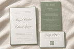 Sage green and ivory wedding invitation suite with a classic bordered invitation, green details card and QR code RSVP card, styled on textured fabric for a romantic old money wedding stationery flat lay.