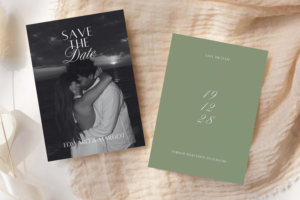 Sage green and black and white photo save the date cards on textured ivory fabric, featuring a romantic couple portrait and stacked script date for classic wedding stationery.