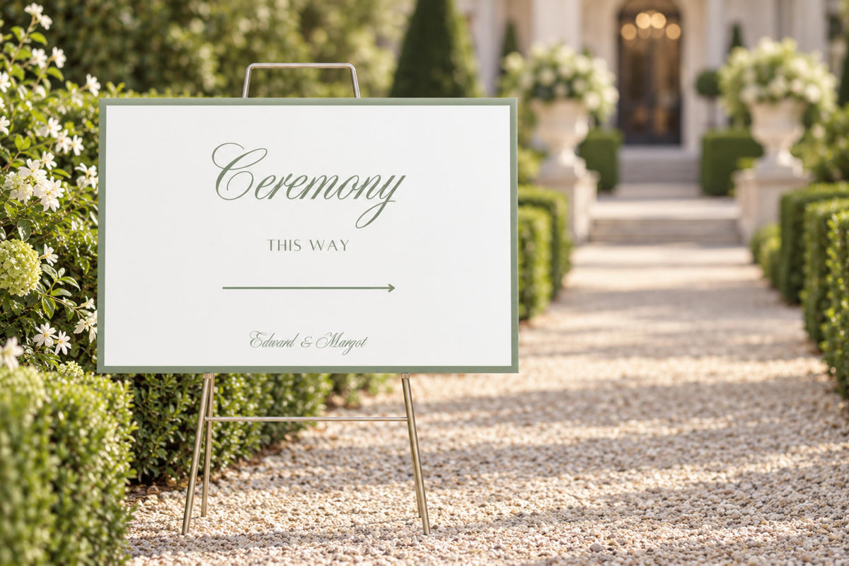 Editable sage green wedding ceremony sign on an easel beside a formal garden walkway, showing a simple ceremony welcome design with a fine green border.