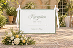 Sage green wedding reception sign template displayed on an easel along a garden pathway, with white flowers and elegant greenery for an outdoor wedding reception.