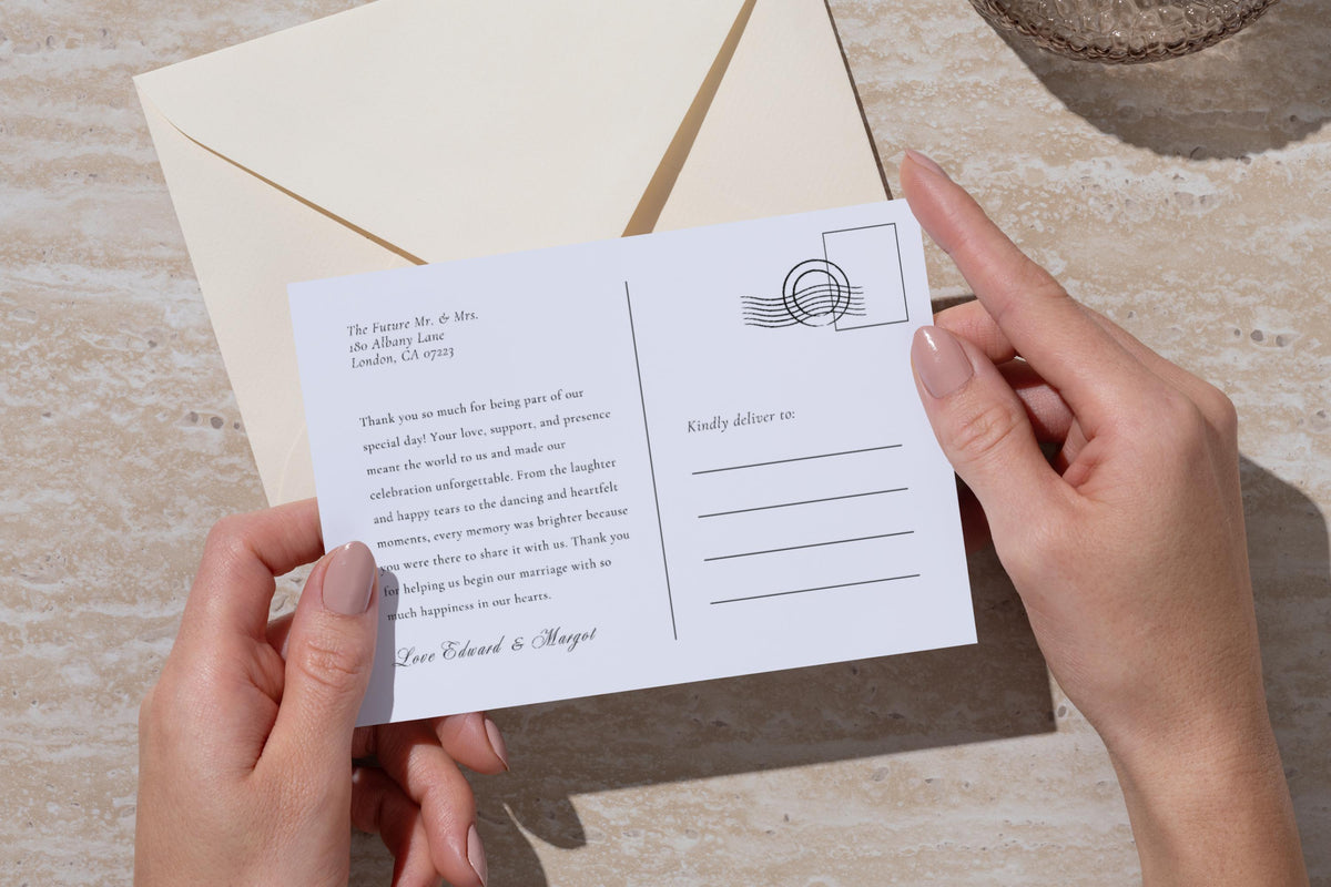 Printable wedding thank you postcard reverse held beside an ivory envelope, featuring a personal message, recipient address lines and illustrated postage stamp detail for timeless newlywed stationery.